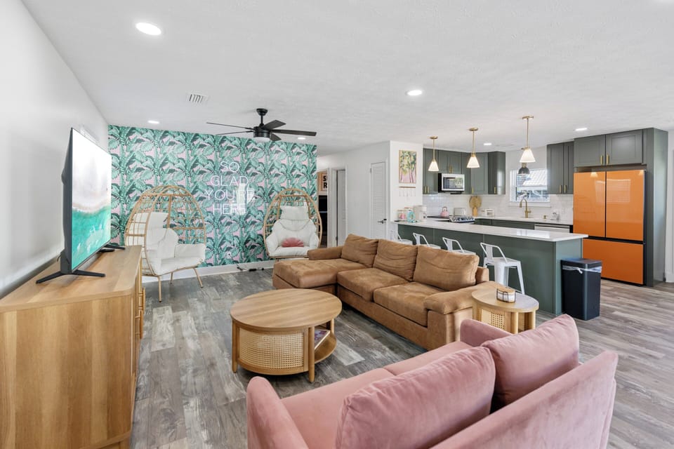 Relax in your stylish open-plan living area with tropical-inspired decor, plush seating, and a fully equipped modern kitchen ready for all your vacation dining.