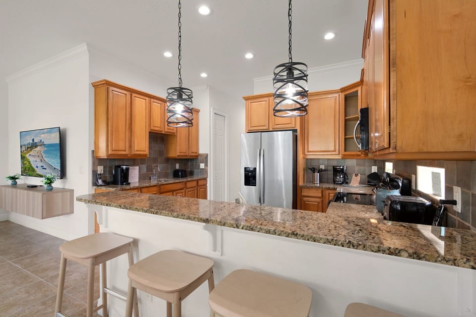 The open-concept kitchen features stainless steel appliances, ample counter space, and everything you need to prepare family meals during your vacation.