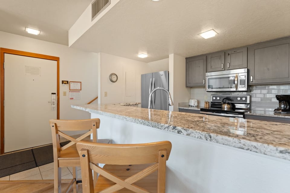 Picture yourself preparing meals on gleaming granite countertops in this fully equipped kitchen, complete with stainless steel appliances and an inviting breakfast bar for casual dining.