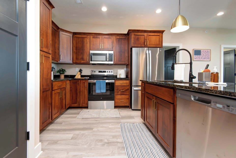 Bright and large kitchen featuring sleek stainless steel appliances, perfect for preparing family meals.
