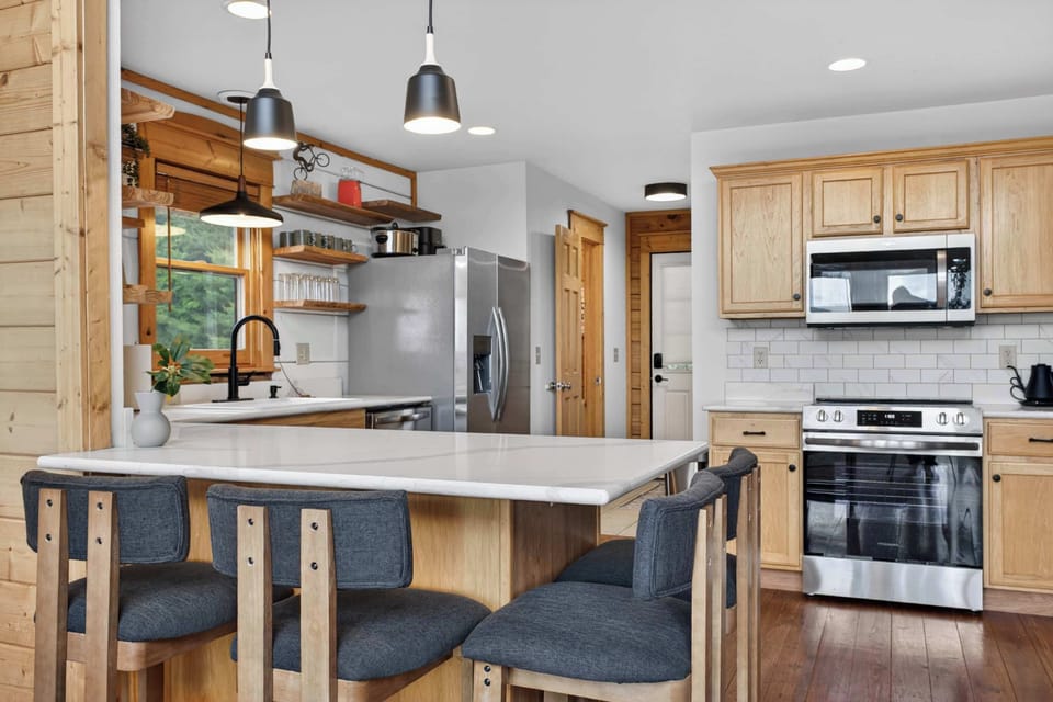 A kitchen that actually works for groups — stainless appliances, bar seating & room to spread out.