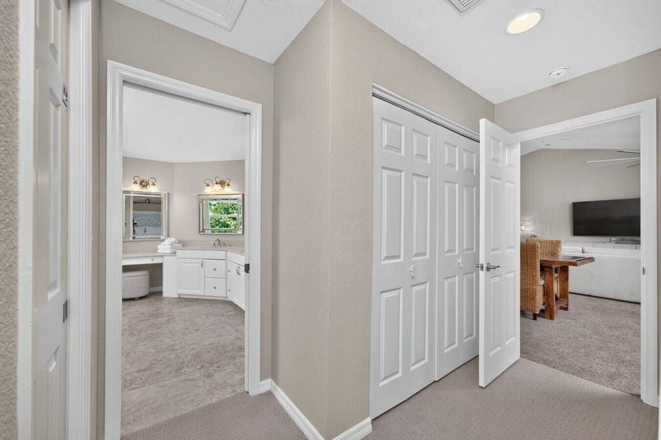 Private primary suite entrance with spacious closet storage and an ensuite bathroom featuring dual vanities—designed for comfort, convenience, and a relaxing stay near Manasota Key Beach.