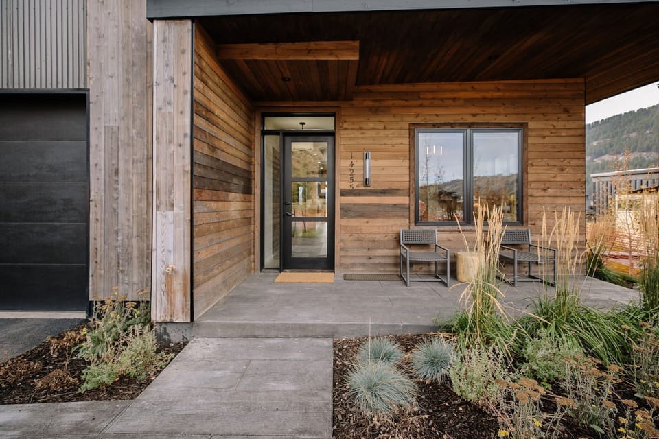 Cabin entrance with landscaping and outdoor chairs