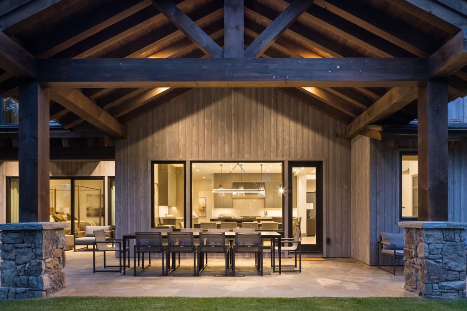 Mountain pines surround the home's exterior on a clear summer day.