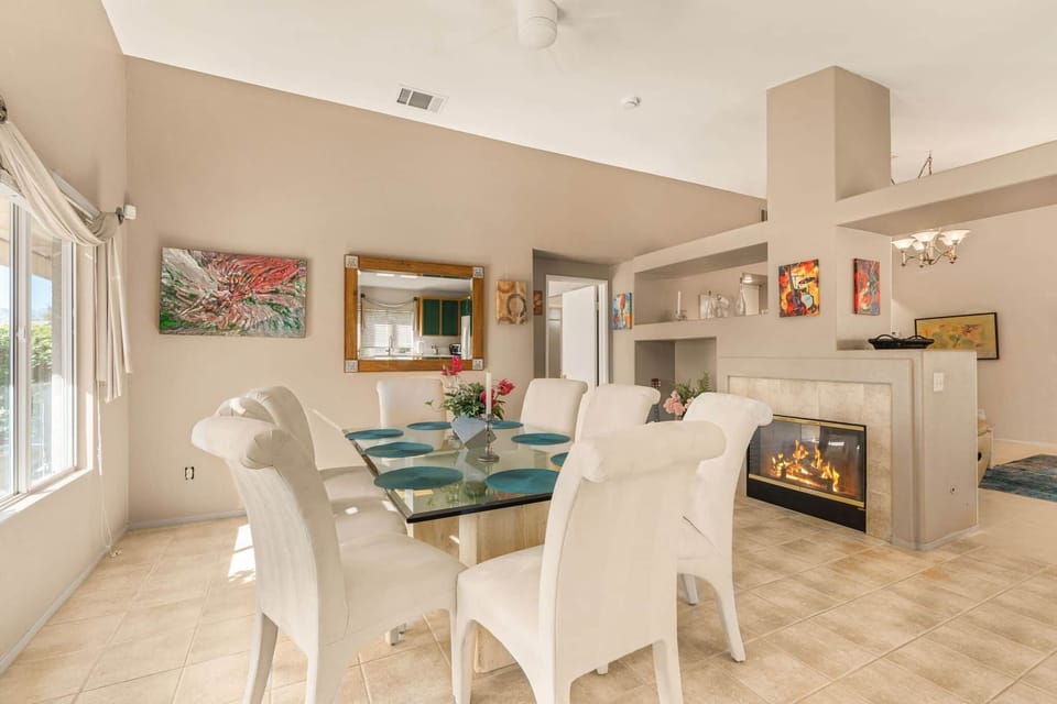 Elegant dining area featuring pristine white upholstery and a glass-top table