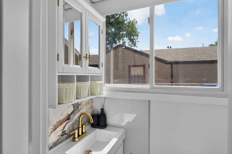 Bright bathroom vanity with large window, natural light, and modern finishes