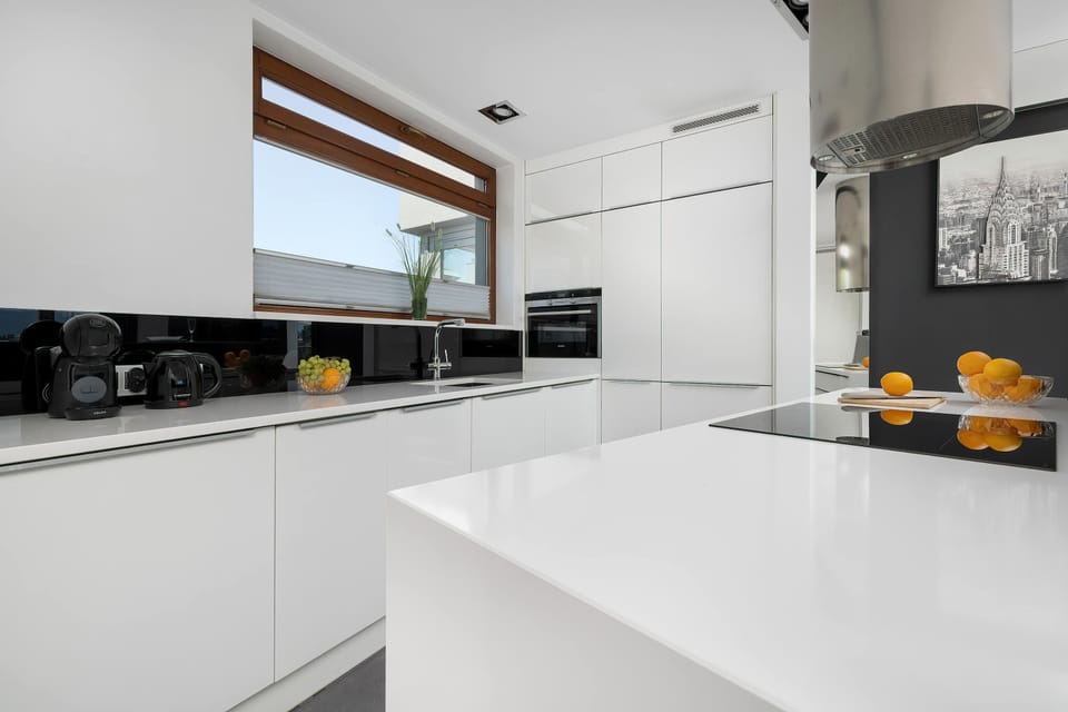 A modern white kitchen with sleek finishes. Everything you need to prepare meals during your stay.
