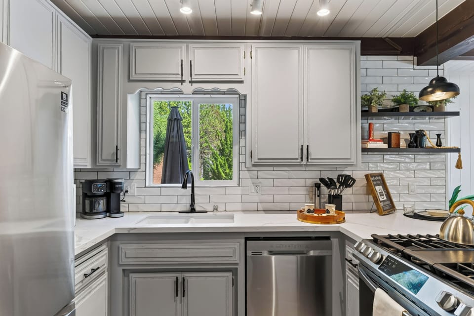 Cook and gather in the bright kitchen, featuring modern appliances and island seating for four.