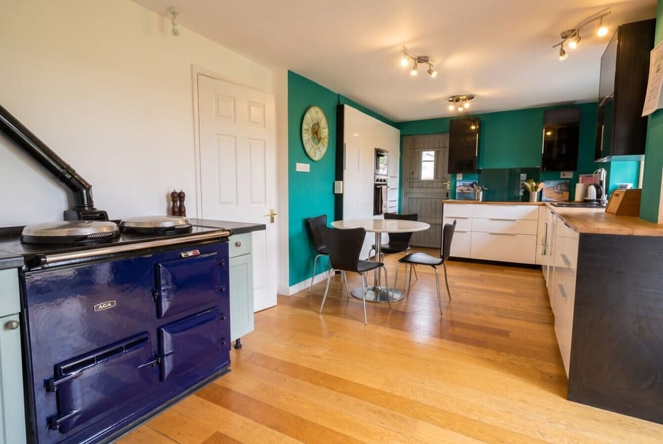 Classic navy Aga anchors this warm country kitchen