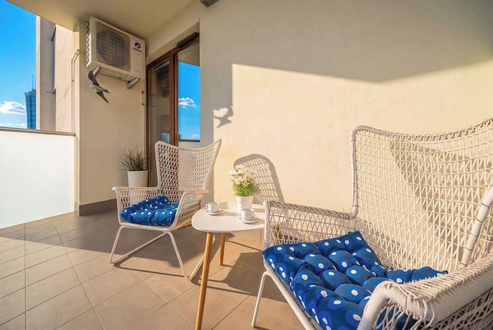 A cozy balcony furnished with comfortable chairs and a small table. Enjoy fresh air while overlooking the surrounding area.