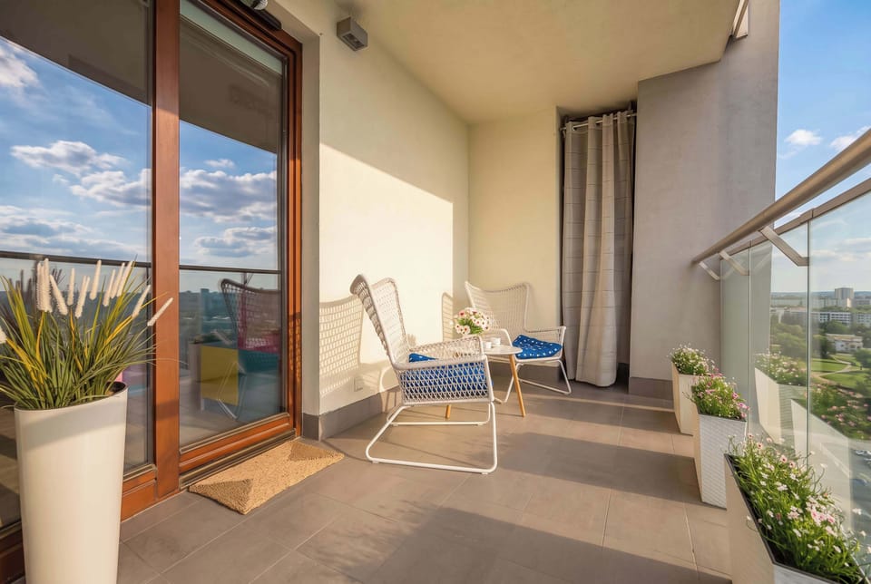 A spacious balcony with outdoor seating and city views. It's a wonderful place for your morning coffee or evening relaxation.