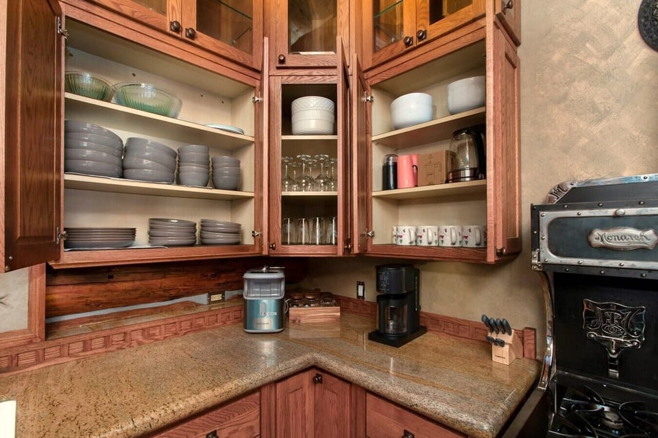 Well stocked kitchen with plates, cups, bowls
