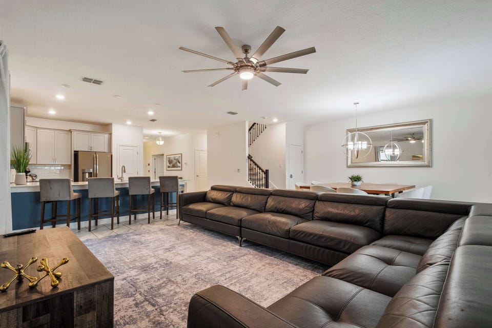 Kick back and unwind in this modern living room featuring comfortable seating, a large Smart TV, and easy access to the outdoor patio. The perfect place to relax after exploring Orlando's top attractions. ☀️📺