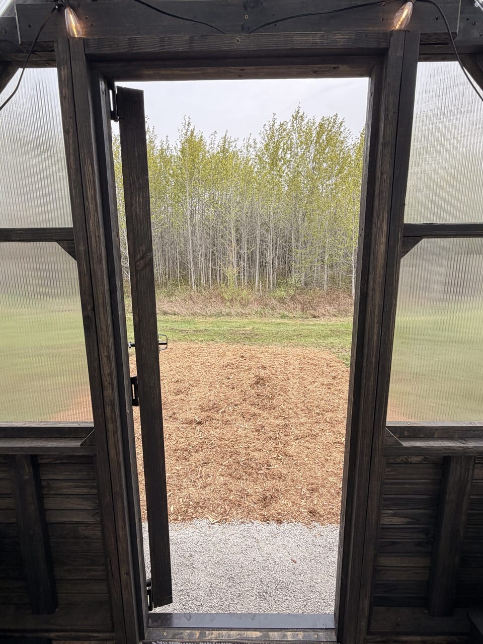 Rustic covered porch opens to peaceful field and wooded views