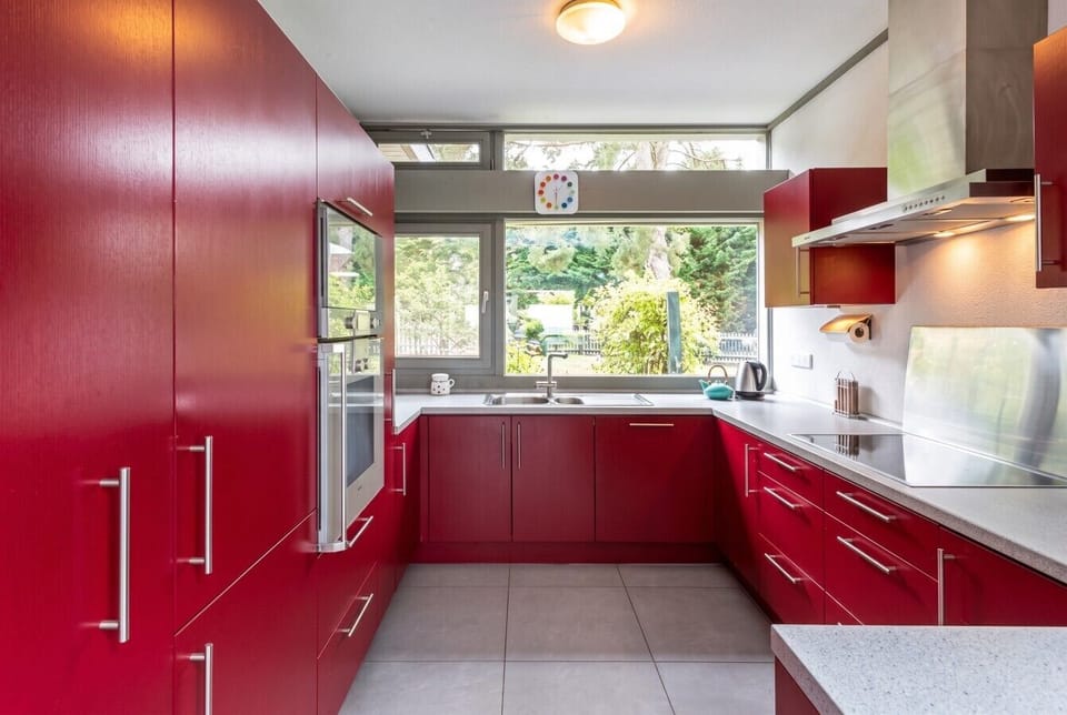 Bold red kitchen fully equipped for relaxed home cooking