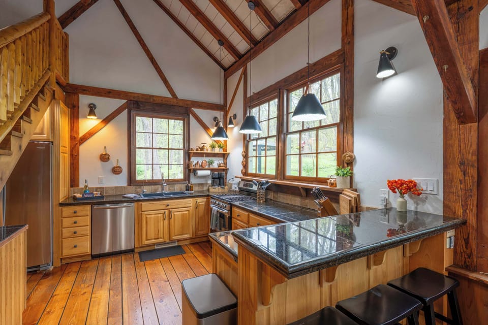 Rustic chef’s kitchen with granite counters, center island, stainless appliances and warm wood cabinetry