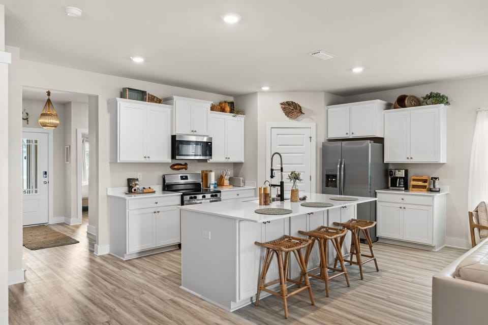 Cook up your favorite recipes in this bright, modern kitchen with sleek appliances, ample counter space, and an inviting island where you can gather for meals or conversation.