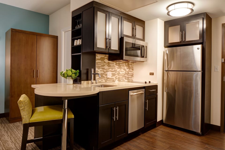 Full kitchen with stainless appliances and seating.