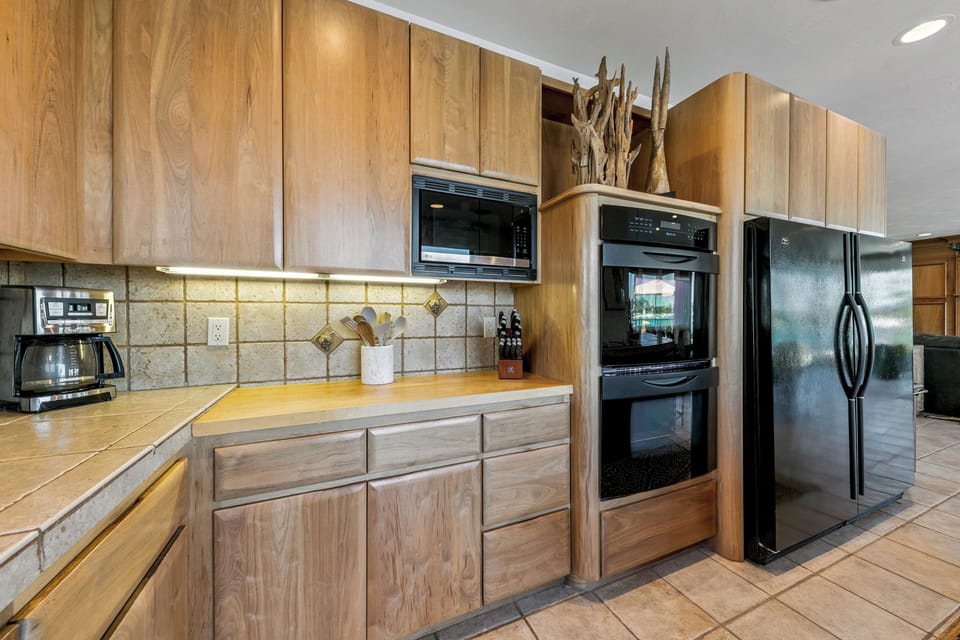 Your fully equipped kitchen features double ovens, a built-in microwave, and a refrigerator—everything you need to whip up family meals or morning coffee in comfort.