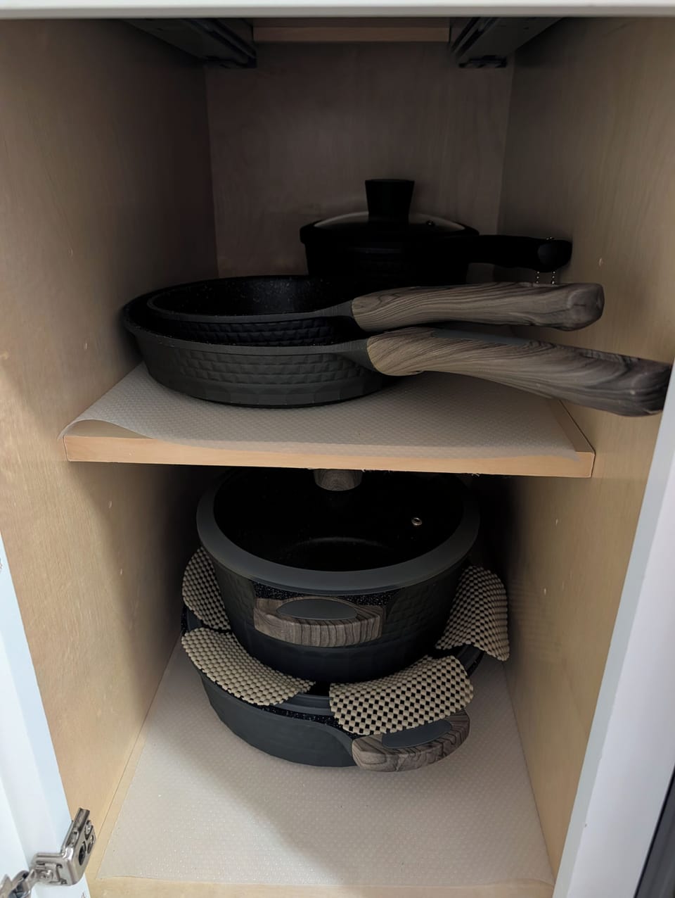 Well-stocked kitchen cabinet with modern cookware for easy home cooking