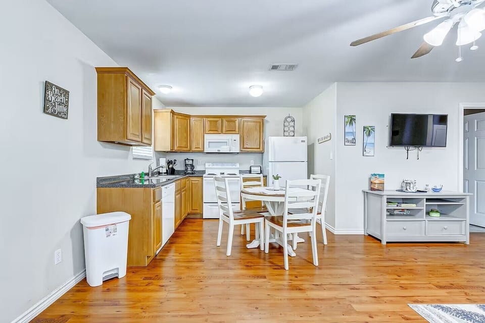 Bright open kitchen and dining space with TV and seating for four