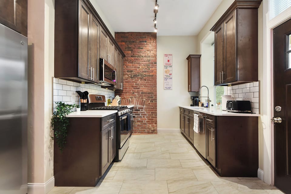 Spacious modern kitchen with exposed brick and stainless steel appliances