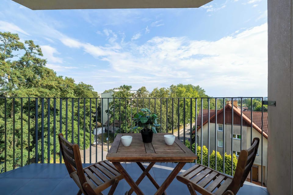 Private balcony furnished with table and chairs, offering perfect spot to enjoy morning coffee or unwind in the fresh air.