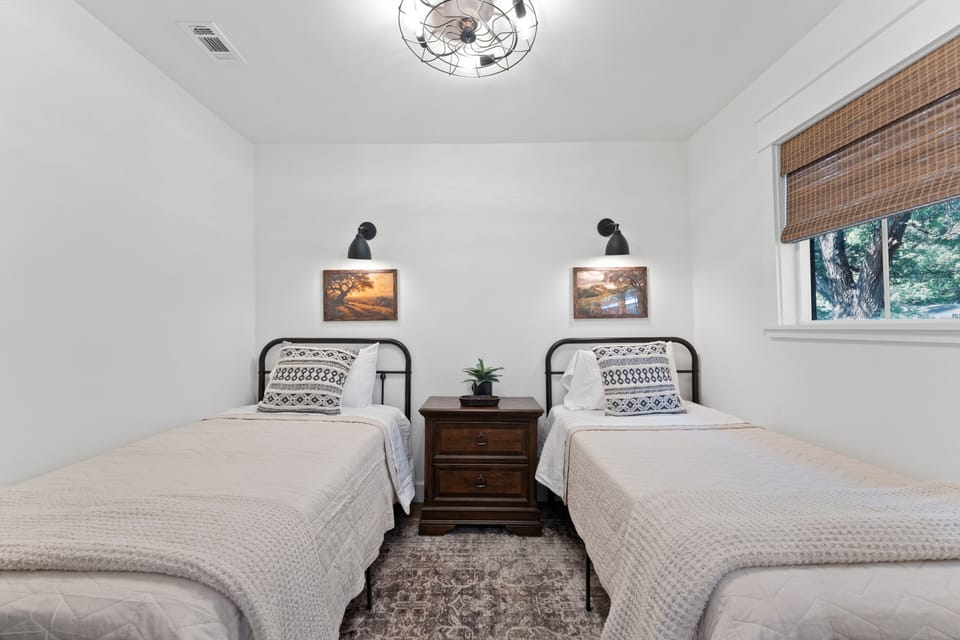 Bright twin bedroom with cozy beds, reading lights, and stylish decor