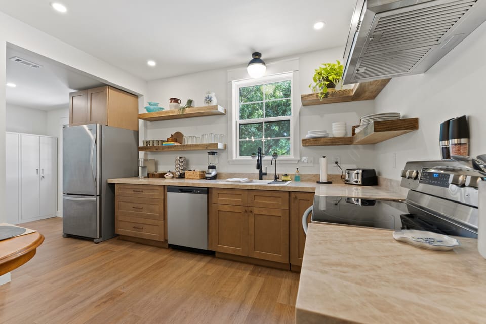 Bright modern kitchen with stainless appliances and stylish open shelving
