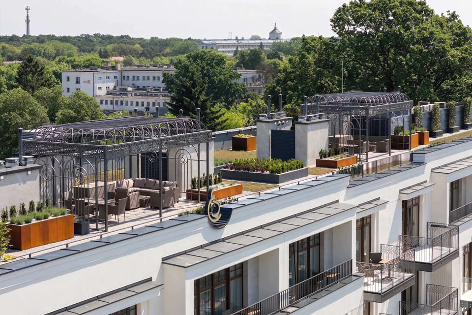 An elevated view of the rooftop terrace and surrounding neighborhood. The modern design creates an inviting outdoor space.