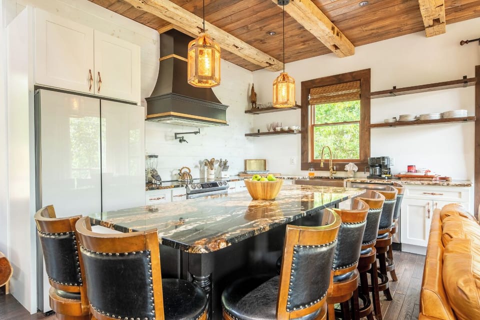 Your gourmet kitchen blends rustic charm with modern convenience—think exposed wood beams overhead, gleaming granite counters, and a spacious island where you can gather for morning coffee or plan the day's adventure together.