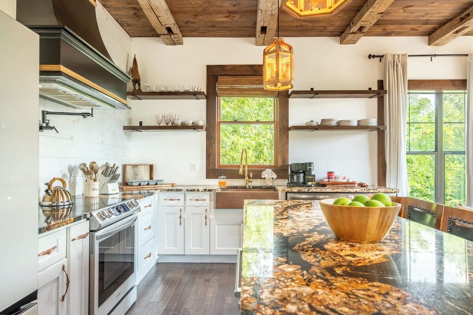 Step into your dream kitchen, where rustic wood beams meet modern convenience. Natural light pours through large windows, illuminating granite countertops and open shelving, making this your perfect space for morning coffee or cooking together.
