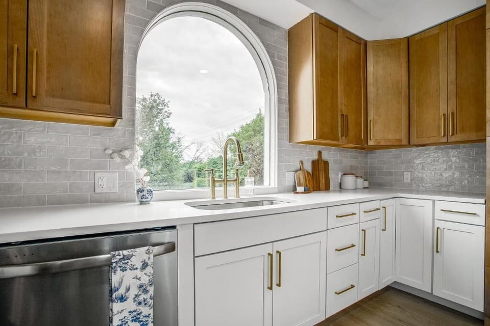 Kitchen sink view with arched windows and natural light.