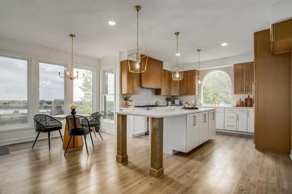 Bright chef’s kitchen with oversized island and elegant lighting.