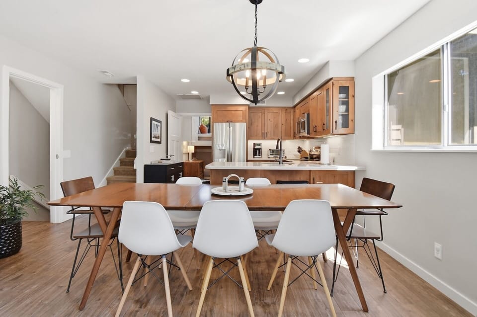 Gather around this inviting dining table where warm wood tones and modern design create the perfect setting for your meals together, with a fully equipped kitchen ready for your culinary adventures.