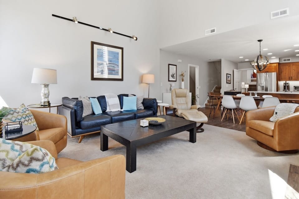 Settle into your spacious open-concept living area, where comfortable seating surrounds a stylish coffee table—perfect for gathering with loved ones. Sunlight streams through, creating a warm, welcoming retreat you'll love coming home to.