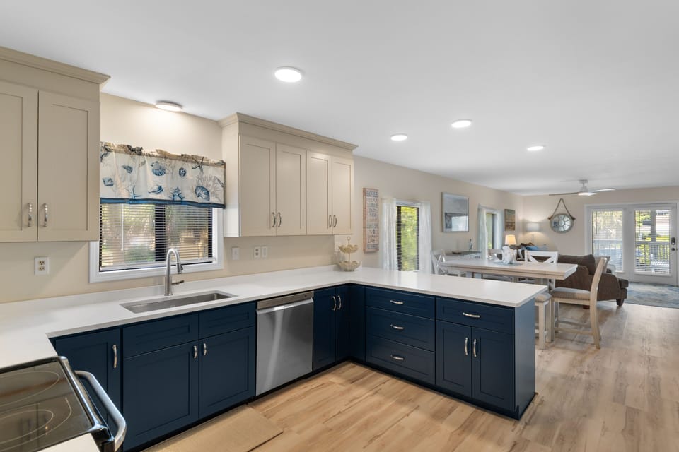 Kitchen peninsula with stainless dishwasher and open sightline to dining and living areas at Ocean Bliss Unit 102, Surfside Beach