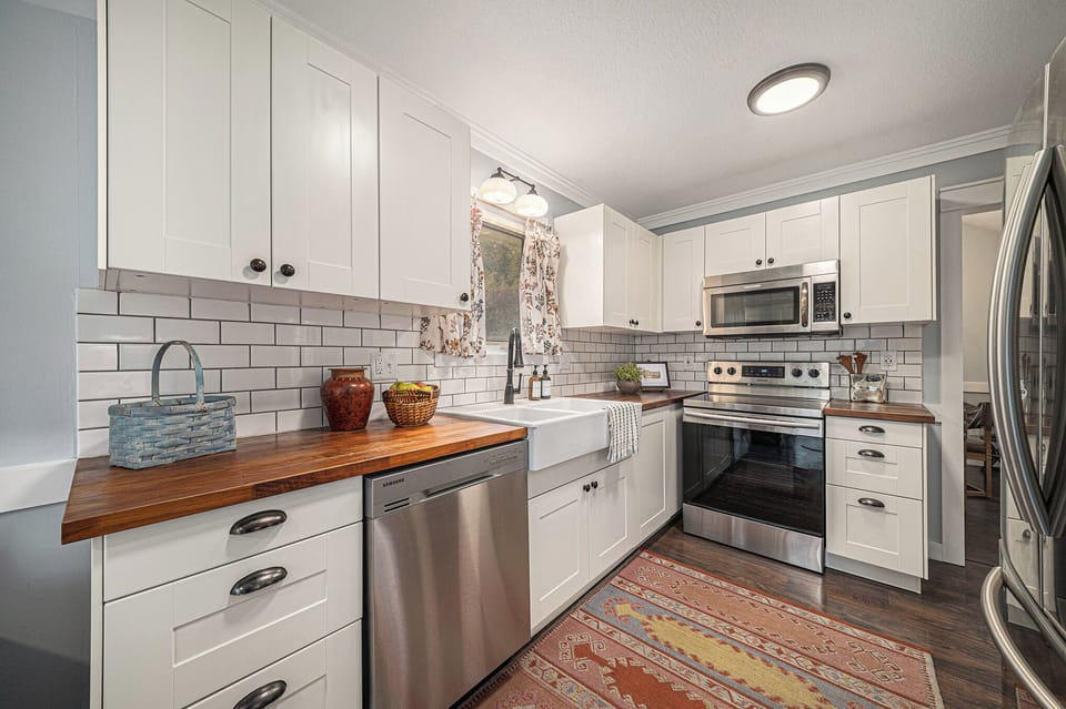 Bright modern kitchen with stainless appliances and warm finishes.