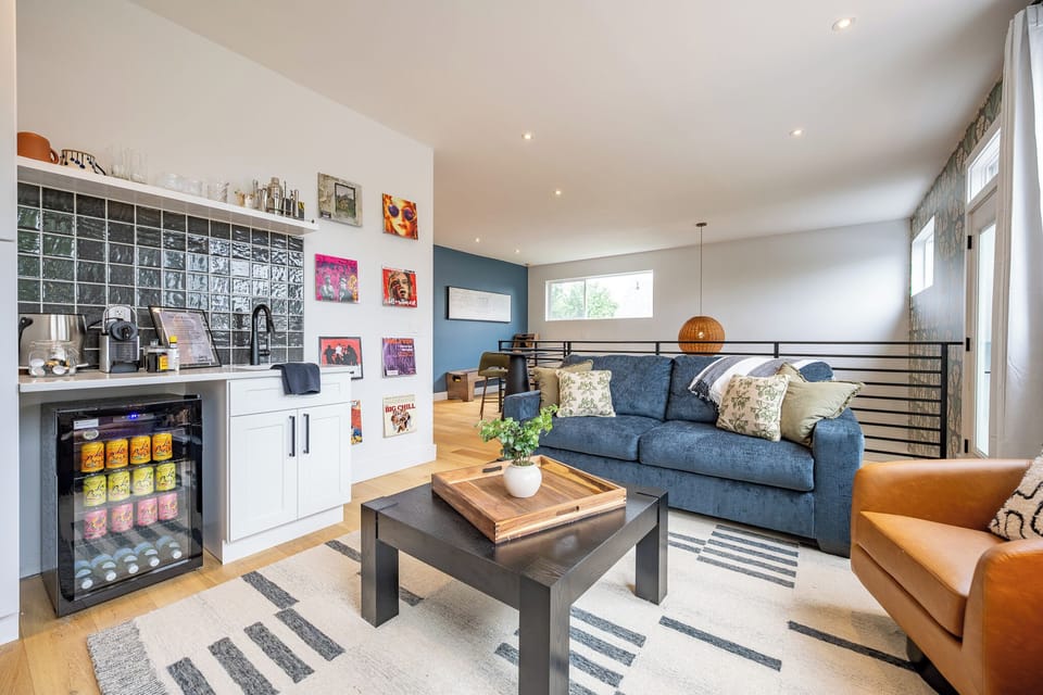 Bright modern lounge with wet bar, mini fridge, and cozy seating