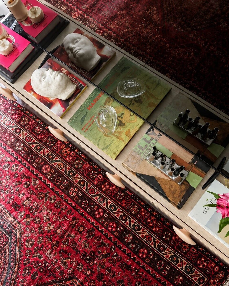 Glass coffee table with curated décor adds charm and boutique hotel style.