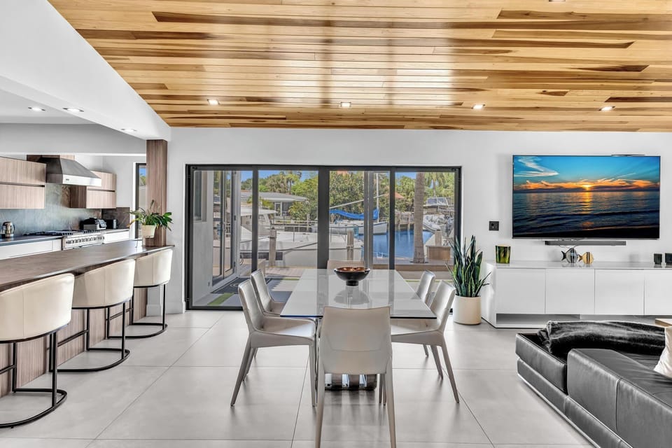 Airy dining area featuring built-in cabinetry and a wall-mounted TV.