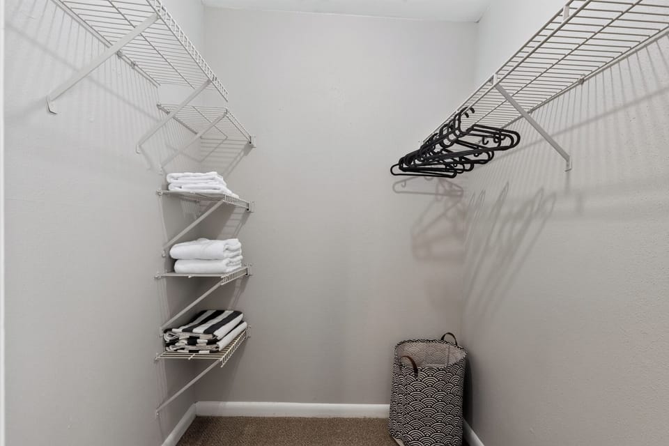 Spacious walk-in closet with extra linens, hangers, and guest storage