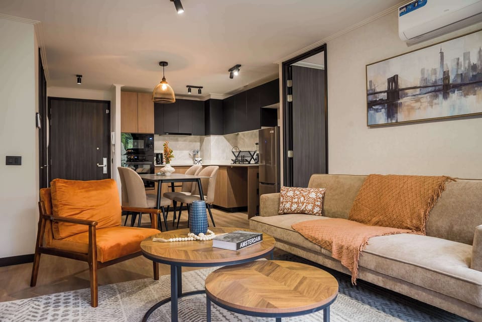 Relax in this stylish living area with a cozy sofa and modern kitchen, perfect for unwinding after exploring the city.