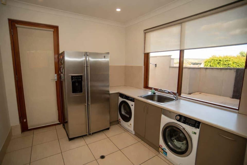 Dedicated laundry room with washer, dryer, and additional full-size fridge-freezer. Ground floor.