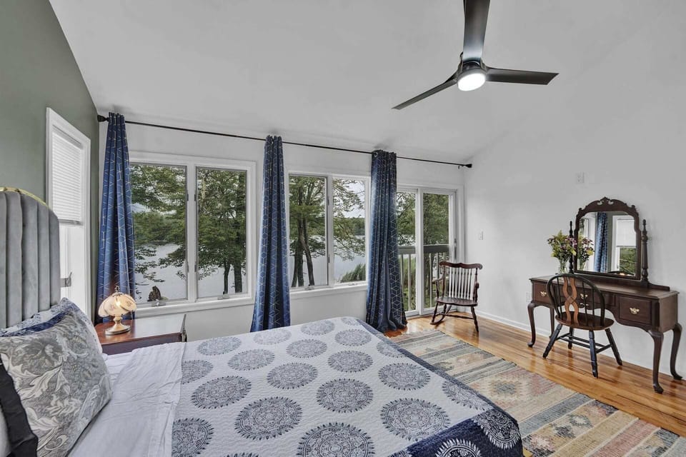 Second bedroom with ceiling fan, multi-use vanity table, and lake views.