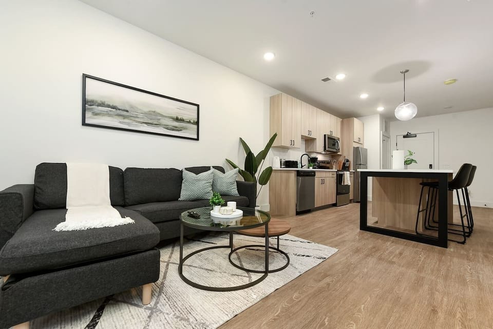 Modern open-plan living area featuring a cozy lounge, sleek kitchen, and island bench seating.