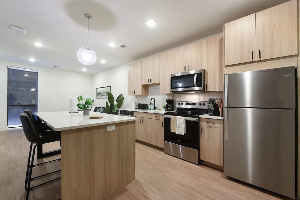 Contemporary kitchen featuring stainless steel appliances, ample storage, and a spacious island with seating.