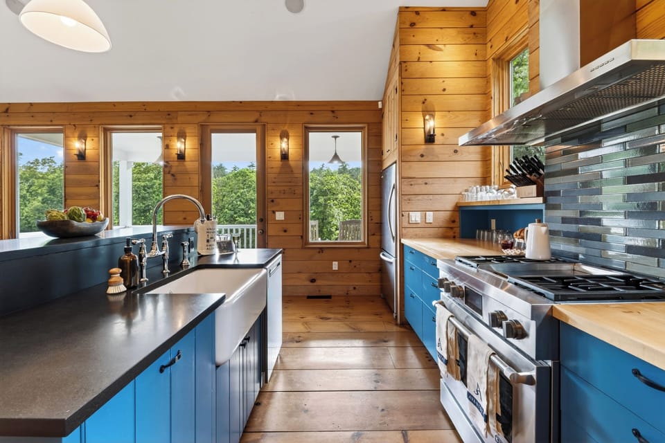 Warm wood kitchen with bold blue cabinetry, vaulted ceilings, and generous island prep space.