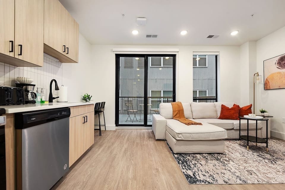 Open-concept living room and kitchen with modern finishes and natural light.