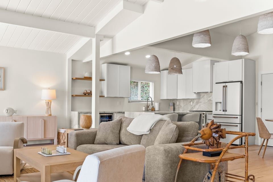 Open-concept San Diego kitchen & living space with vaulted ceilings, marble finishes, stainless appliances & modern coastal design. Bright, airy layout perfect for cooking, entertaining, group stays & enjoying a luxury vacation retreat.